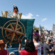 Moana on a parade float, waving at guests at Disney World.